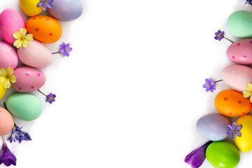 Wall Mural - Easter decoration. Easter eggs and blue flowers hepatica, violet crocuses, yellow primula on a white background with space for text. Top view, flat lay