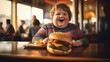 Overweight boy eating burger, blurred cafe background