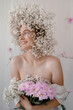 Portrait of sensual blond woman with flowers. Beautiful girl with flowers in her hair. Summer Beauty. Art in a contemporary style. A gypsophila wreath on a white background. Perfume, cosmetics concept
