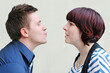 Ein Mann möchte eine Frau küssen, die ihn dabei belustigt ansieht