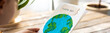 Banner. Concept of raising awareness about the environmental issues on the Earth day. Kid doing craft postcard with planet on it. Promoting sustainable lifestyle, environment protection
