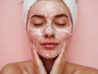 Beautiful young woman with mask on her face. Facial treatment. Cosmetology, beauty and spa.