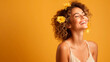 © Ignacio Carrera - A positive, relaxed, smiling woman enjoying flowers in the spring season, yellow background