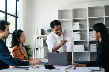 Two women and two men in a business meeting, Diverse business people laughing during a meeting, Business colleagues discussing strategy in the office, Business people negotiating at boardroom.