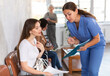 © JackF - Nurse explains to girl how to fill out documents for a doctor appointment