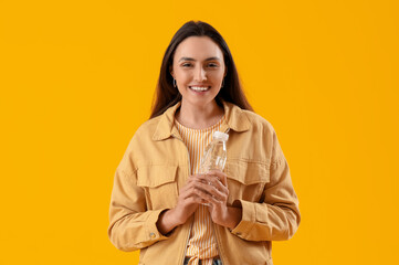 Sticker - Young woman with bottle of water on yellow background