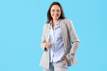 Wall Mural - Young businesswoman with bottle of water on color background