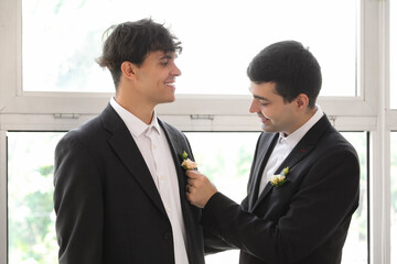 Poster - Young man fixing his husband's boutonniere on their wedding day