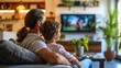 © sirisakboakaew - Happy family watching tv front view on sofa. Home leisure lifestyle.