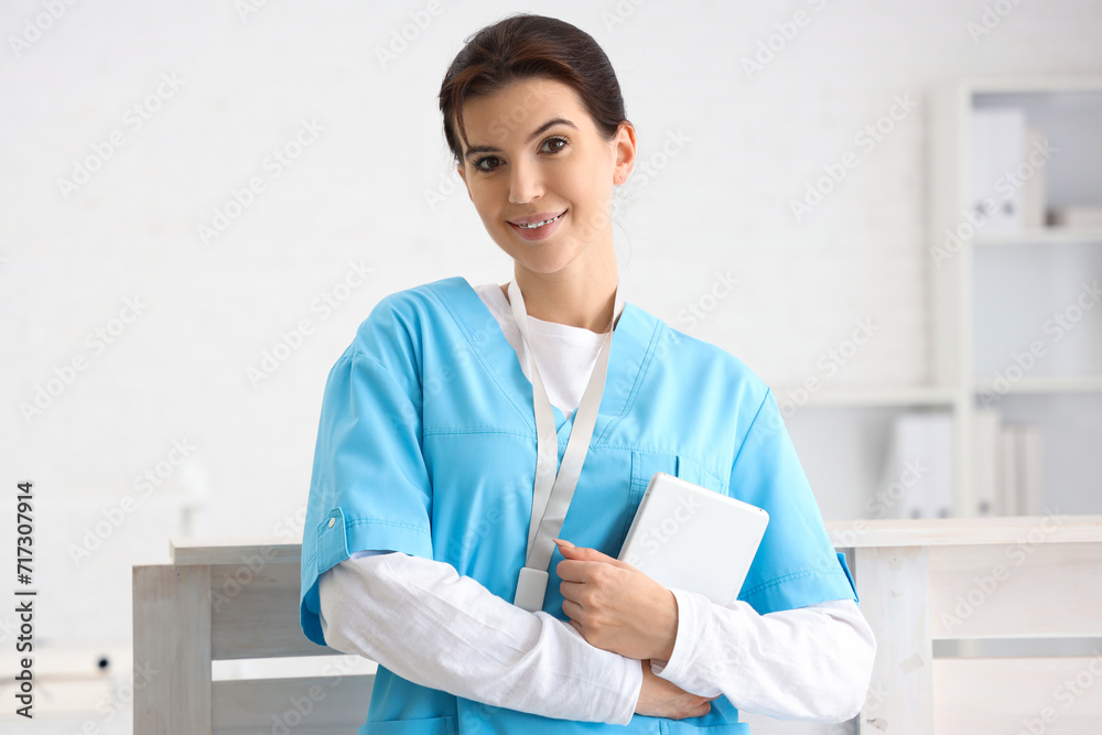 Female medical intern with tablet computer in clinic