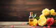 A bottle of essential oil, by blooming pink roses and fresh lemon halves, set against a warm, bokeh light background