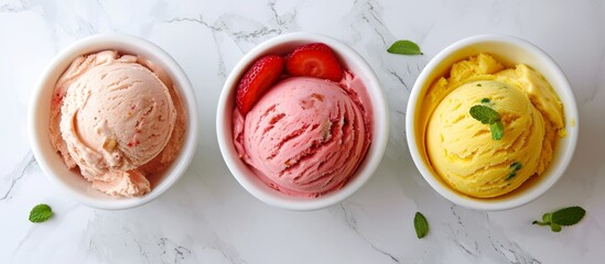 Canvas Print - Ice cream with strawberry, mango/banana, and lime/green tea/pistachio flavors in white bowls on a white marble background, viewed from the top.