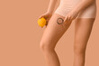 © Pixel-Shot - Beautiful young woman with cellulite problem, magnifier and orange on brown background