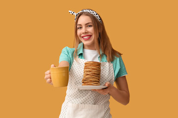 Sticker - Happy young woman with tasty pancakes and cup of tea on yellow background