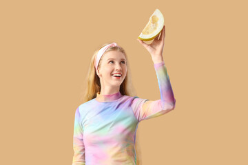 Canvas Print - Young woman with pomelo piece on beige background