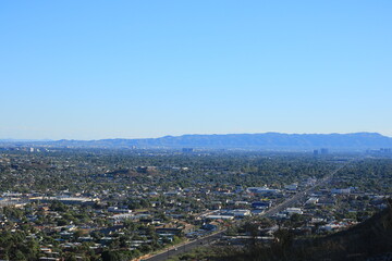 Wall Mural - Late afternoon bluish haze over Arizona Capital City of Phoenix downtown under cloudless sky as seen from North Mountain Park toward South mountains