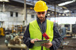 © lovelyday12 - Warehouse workers wear helmets Surrounded by industrial and construction elements. Demonstrate safety, hard work and use tablet to check machine data
