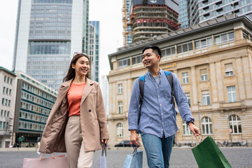 Wall Mural - Asian young man and woman shopping goods outdoors in department store.