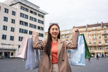 Wall Mural - Portrait of Asian woman shopping goods outdoor in department store. 