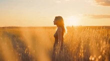 Wide Angle Shot Of A Woman In A Grass Field At Golden Hour 