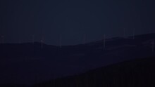 Wind Turbine Mill Flashing Red Light Far Away On Forest Hill Appalachian Mountain At Night Panning Left