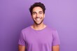 © Iigo - Portrait of a handsome young man smiling and looking at camera while standing against purple background