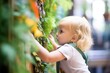 child touching leaves of a sensory vertical garden