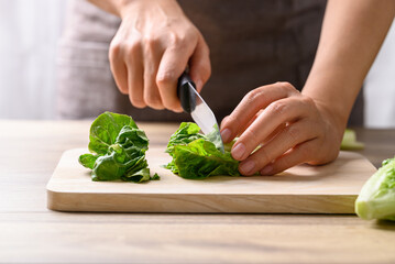 Wall Mural - Organic cos romaine lettuce cutting on wooden board, Food ingredient for healthy salad