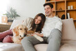 © Maria Vitkovska - Portrait of beautiful, smiling couple, attractive man and woman petting golden retriever