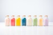 row of colorful protein smoothies in bottles against a white backdrop