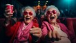 © liliyabatyrova - Two cute smiling old lady friends wearing pink suits and glasses are watching a comedy movie at the cinema. Senior women 60-70 years old have fun, fool around and enjoy life.