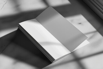 Poster - A white book sits on top of a table next to a window. This versatile image can be used for various themes and concepts