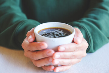 Closeup image of a woman holding a cup of hot coffee