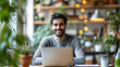 An image of a contented Arab freelancing man sitting at his desk in his home office, grinning at the screen
