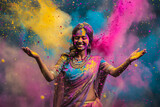Holi concept - indian females wears sari, dances in splashes of holi colored powders