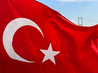 Turkish flag fluttering in the wind with Istanbul and the Golden Horn Bridge in the background, Turkey