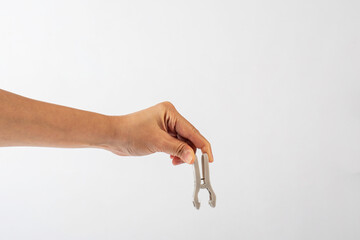 Wall Mural - Close up of clothes peg in hand on white background