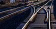 Railway track panorama with high contrast at evening twilight. Reflecting and glistening rails, switches and crossings on main line in Hagen Germany. Technical infrastructure and symbolic background. 