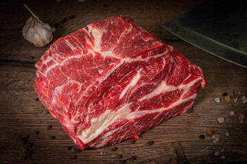 Poster - Raw beef steak with spices on a dark slate, stone or concrete background. Top view with copy space.