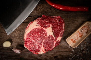 Wall Mural - Organic machete or hanger butcher steak, near butcher knife with pink pepper and rosemary. Black background. Top view. side view