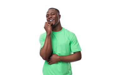 Wall Mural - portrait of young smart african man dressed in green t-shirt and jeans isolated on white background