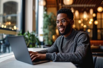 Candid portrait of an African American man working on a laptop in a stylish modern cafe hotel lobby, Generative AI