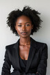 © Lorne Thomson - Visionary Young African American Businesswoman in Sleek Black Suit on a Plain Background