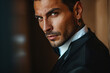 © ALL YOU NEED studio - tanned skin, hot and attractive Italian mafia billionaire with a tattoo on his neck , wearing a luxurious black suit. Looking at camera with piercing and sensual gaze .