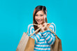 Happy Chinese Woman holding shopping bags.