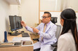 © kelvn - Mature male doctor explain to the woman patient the result of x-ray that show fracture of her calcaneus. Doctor Showing X-ray To Patient On Computer Screen.