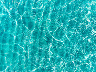 Blue water surface viewed from above in outdoor sea, sun reflection, dimply. Surface Abstract Background. Clear water in sea with ripple in clean aqua liquid. Summer wallpaper blue background