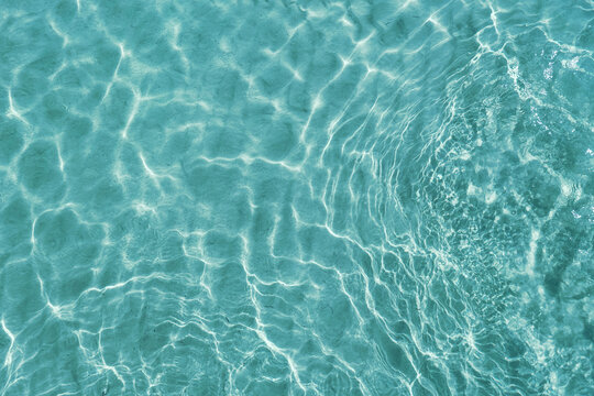 blue water surface viewed from above in outdoor sea, sun reflection, dimply. surface abstract backgr