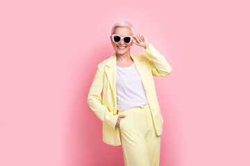 Poster - Photo successful rich businesswoman touching sunglasses wear yellow suit posing at fashion week festival isolated on pink color background