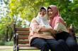 © Prot - Muslim careful caregiver or nurse taking care of the patient in the hospital park. Happy Muslim mother in hijab hugging daughter. Concept of Savings and Senior Health Insurance, a Happy Family